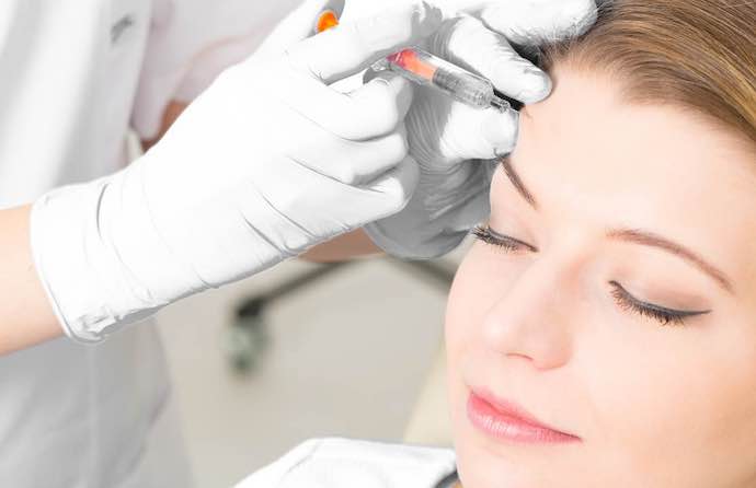 woman receiving a botox injection in the forehead